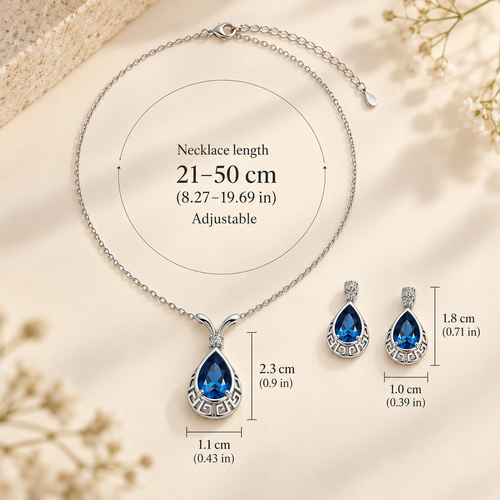 Silver necklace and matching earrings set with teardrop-shaped blue gemstones, shown with overlaid dimension labels for necklace length and piece sizes on a soft beige background.